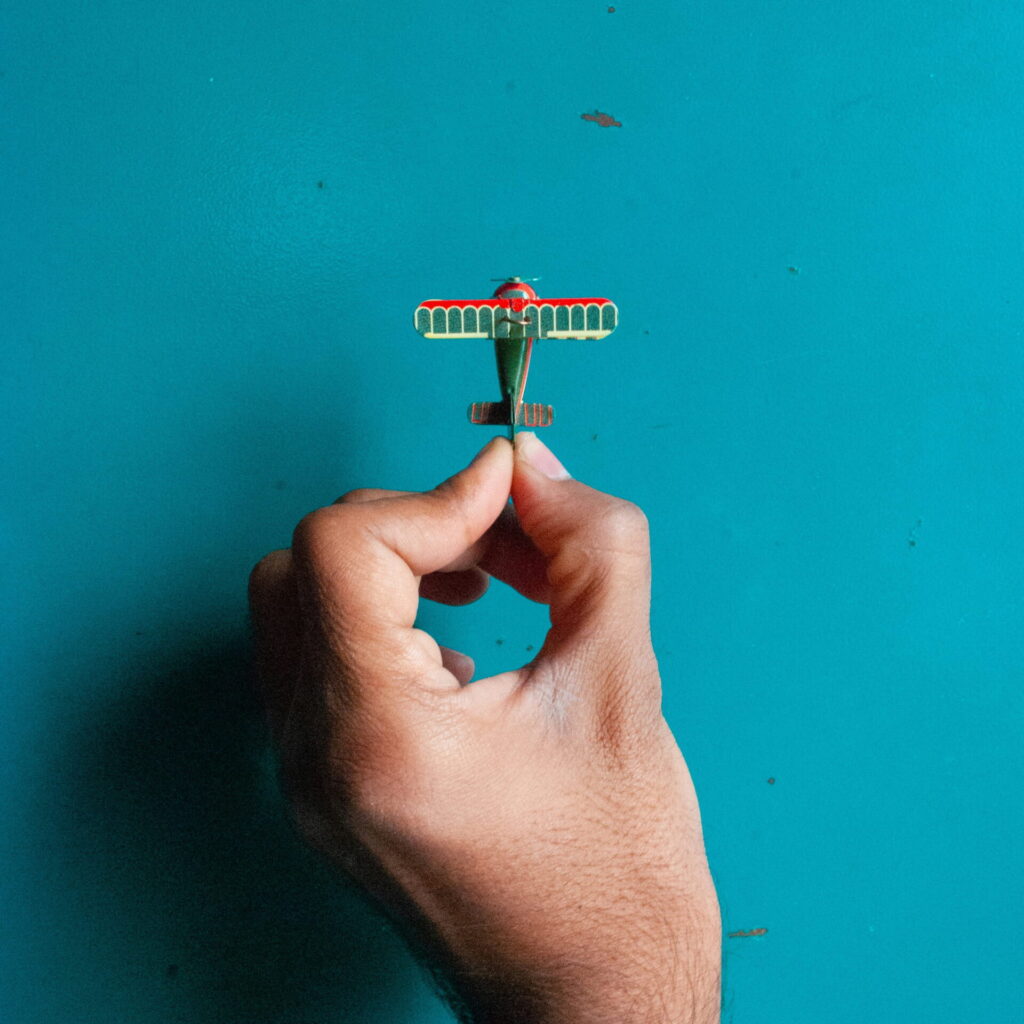 Hand holding green airplane toy